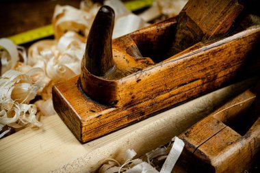 Working tool. Planer with wooden shavings. On a wooden background. High quality photo