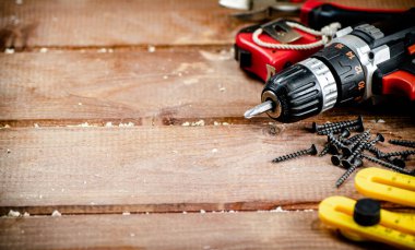 Working tool. Screwdriver with self-tapping screws on the table. On a wooden background. High quality photo