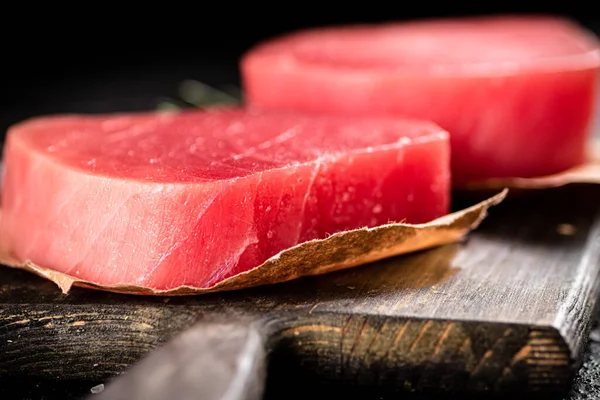 stock image Raw tuna steak on a cutting board. On a black background. High quality photo