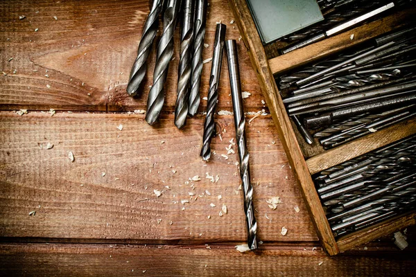 Various drill bits for drills. On a wooden background. High quality photo