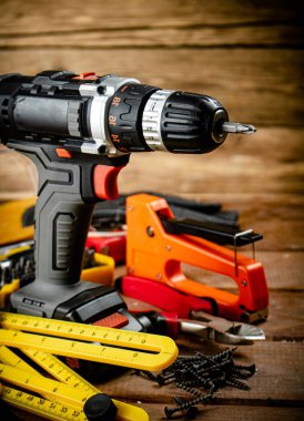 Working tool. Screwdriver with self-tapping screws on the table. On a wooden background. High quality photo