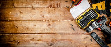 Working tool. Screwdriver with self-tapping screws on the table. On a wooden background. High quality photo