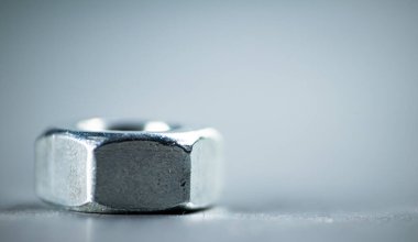 Working tool. Metal nuts on the table. On a gray background. High quality photo