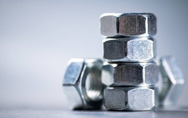Working tool. Metal nuts on the table. On a gray background. High quality photo
