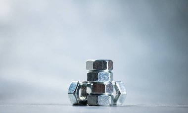 Working tool. Metal nuts on the table. On a gray background. High quality photo