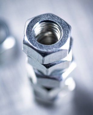 Working tool. Metal nuts on the table. On a gray background. High quality photo