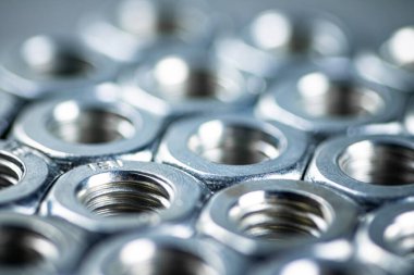 Working tool. Metal nuts on the table. On a gray background. High quality photo