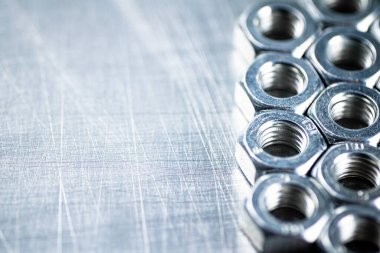 Working tool. Metal nuts on the table. On a gray background. High quality photo