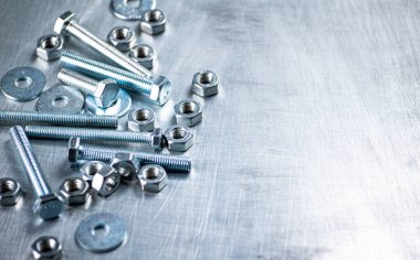 Working tool. Nuts and bolts on the table. On a gray background. High quality photo