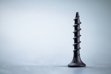 A bunch of self-tapping screws on the table. On a gray background. High quality photo
