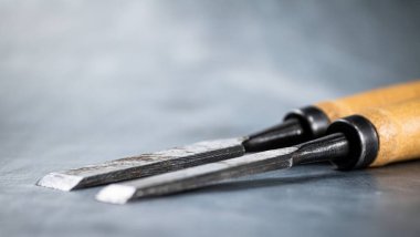 Chisel on wood on the table. On a gray background. High quality photo