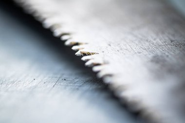 The blade of a hand saw on a gray background. High quality photo