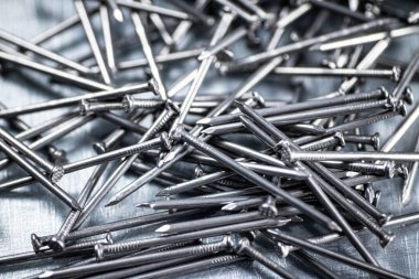 A bunch of nails on the table. On a gray background. High quality photo