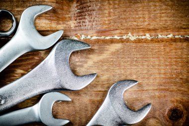 Wrenches with nuts on the table. On a wooden background. High quality photo