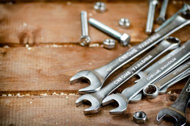 Wrenches with nuts on the table. On a wooden background. High quality photo