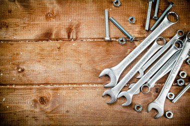 Wrenches with nuts on the table. On a wooden background. High quality photo