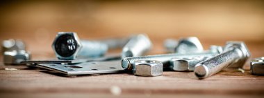 Metal plates for fastening. On a wooden background. High quality photo