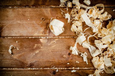 Wooden shavings on the table. On a wooden background. High quality photo