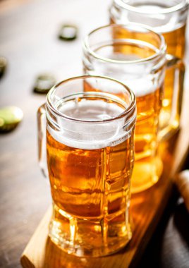 Taze biralı bardaklar. Ahşap arka planda.