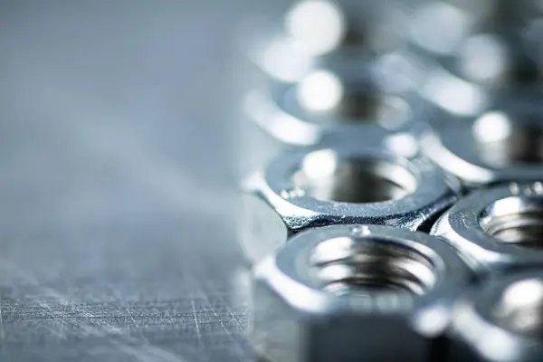 stock image Working tool. Metal nuts on the table. On a gray background. High quality photo