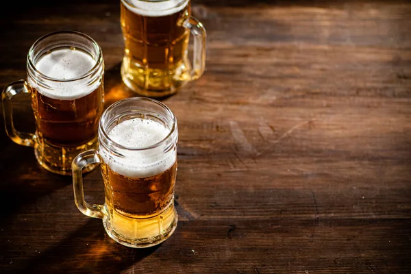 stock image Glasses with fresh beer. On wooden background.