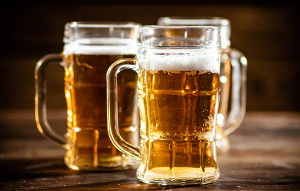 stock image Glasses with fresh beer. On wooden background.