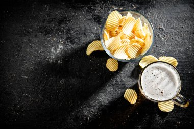 Patates cipsi ve bir bardak bira. Kırsal arkaplanda.