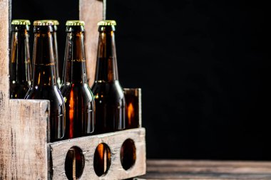 Bira şişeleri eski bir kutuda. Ahşap arka planda.