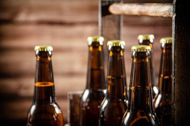 Bira şişeleri eski bir kutuda. Ahşap arka planda.