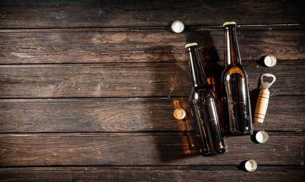 Bottiglie Con Birra Apribottiglie Sfondo Legno — Foto Stock