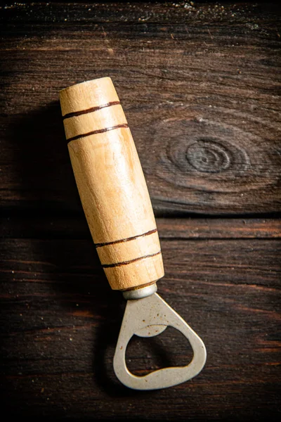 stock image Beer opener. On wooden backgrund.