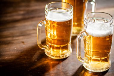 Taze biralı bardaklar. Ahşap arka planda.