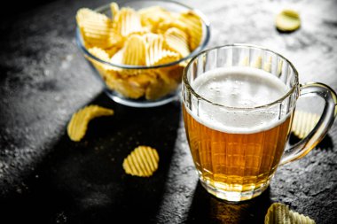 Patates cipsi ve bir bardak bira. Kırsal arkaplanda.