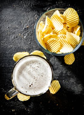 Patates cipsi ve bir bardak bira. Kırsal arkaplanda.