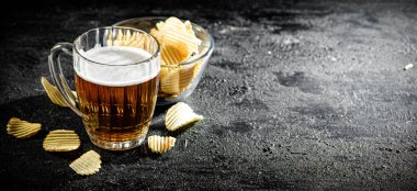 Patates cipsi ve bir bardak bira. Kırsal arkaplanda.