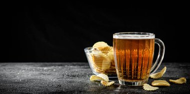 Patates cipsi ve bir bardak bira. Kırsal arkaplanda.