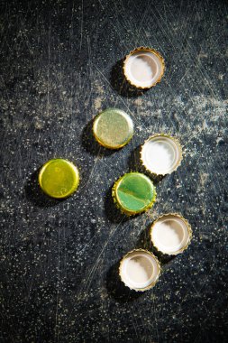 Birkaç bira şişesi kapağı. Kırsal arkaplanda.