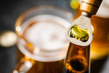 Bira şişesi ve açacağı. Kırsal arkaplanda.