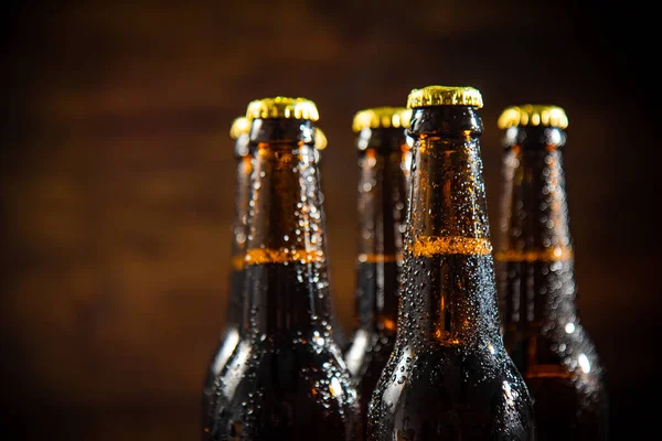 stock image Fresh beer in closed bottles. On rustic background.