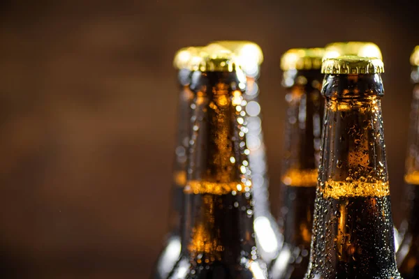 Stock image Fresh beer in closed bottles. On rustic background.