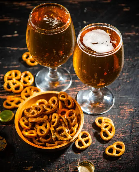 stock image Beer with salty pretzels. On rustic background.