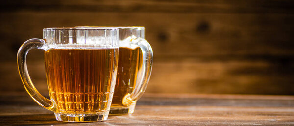 Fresh beer in glasses. On rustic background.