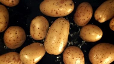 Patatesler su damlalarıyla uçar. Film, yavaş çekim 1000 fp. Yüksek kaliteli FullHD görüntüler