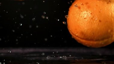 Portakallar masaya düşer. Film, yavaş çekim 1000 fp. Yüksek kaliteli FullHD görüntüler