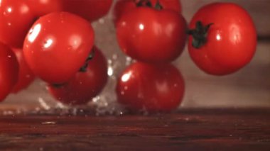 Domatesler masaya düşer. Film, yavaş çekim 1000 fp. Yüksek kaliteli FullHD görüntüler