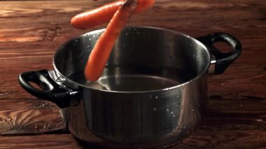 Havuç bir tencere suya düşer. Film, yavaş çekim 1000 fp. Yüksek kaliteli FullHD görüntüler