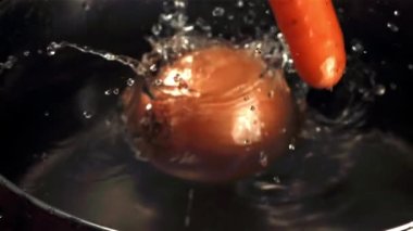 Sebzeler tavaya düşer. Film, yavaş çekim 1000 fp. Yüksek kaliteli FullHD görüntüler