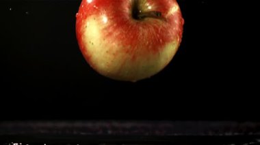 Elma masaya düştü. Film, yavaş çekim 1000 fp. Yüksek kaliteli FullHD görüntüler