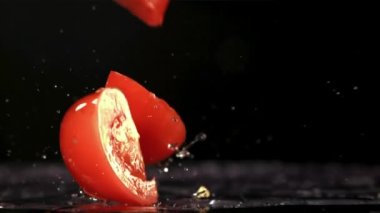 Domates dilimleri masaya düşer. Film, yavaş çekim 1000 fp. Yüksek kaliteli FullHD görüntüler