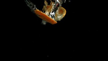 Portakal dilimleri suya düşer. Film, yavaş çekim 1000 fp. Yüksek kaliteli FullHD görüntüler